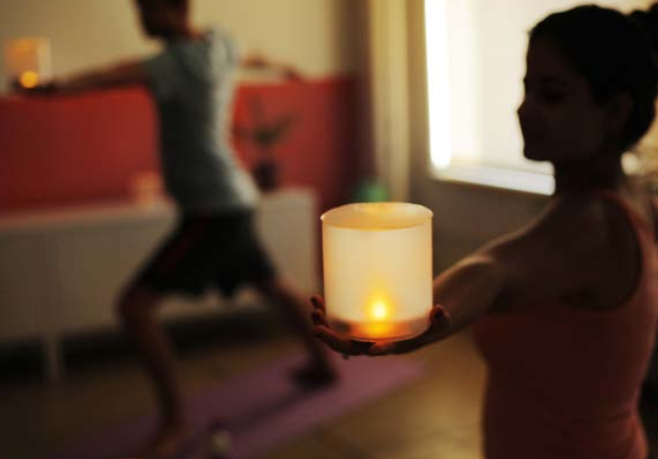 yoga pose with solar candles in hand